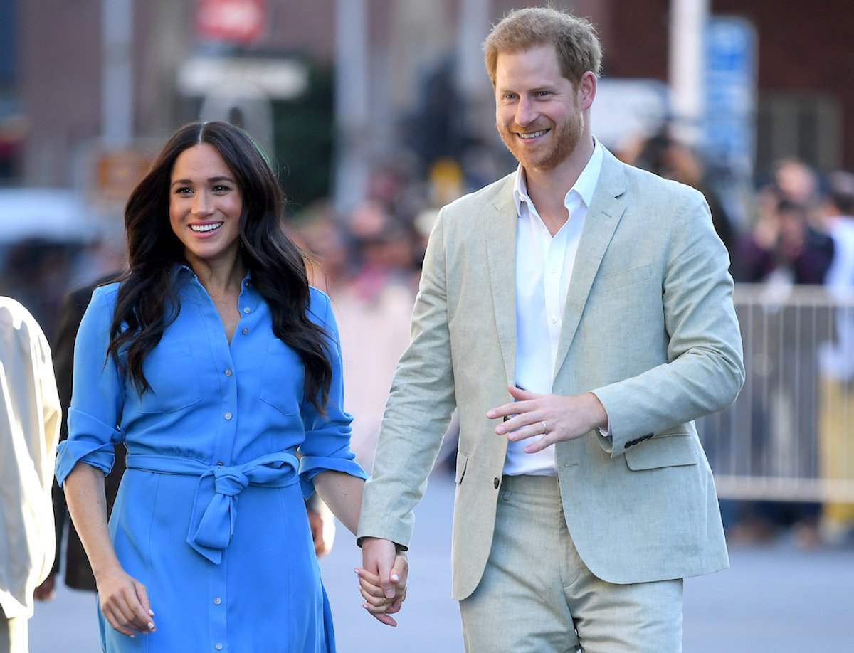 Meghan Markle and Prince Harry, whose Africa trip suggested to a commentator Prince Harry sent a message to 'doubters' about him and Meghan Markle, walk in Cape Town, South Africa