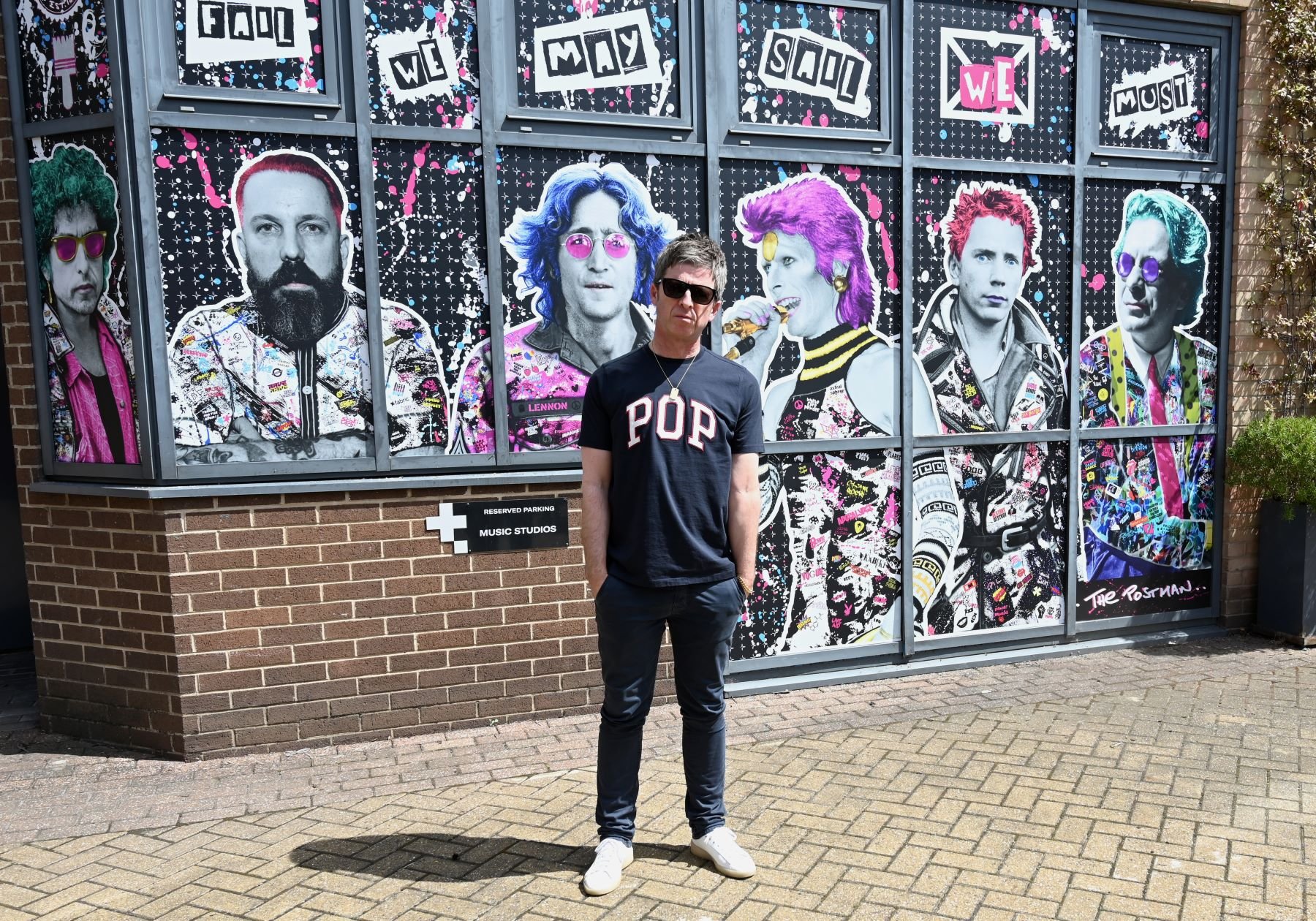 Noel Gallagher posing at completed The Postman art mural in London, England