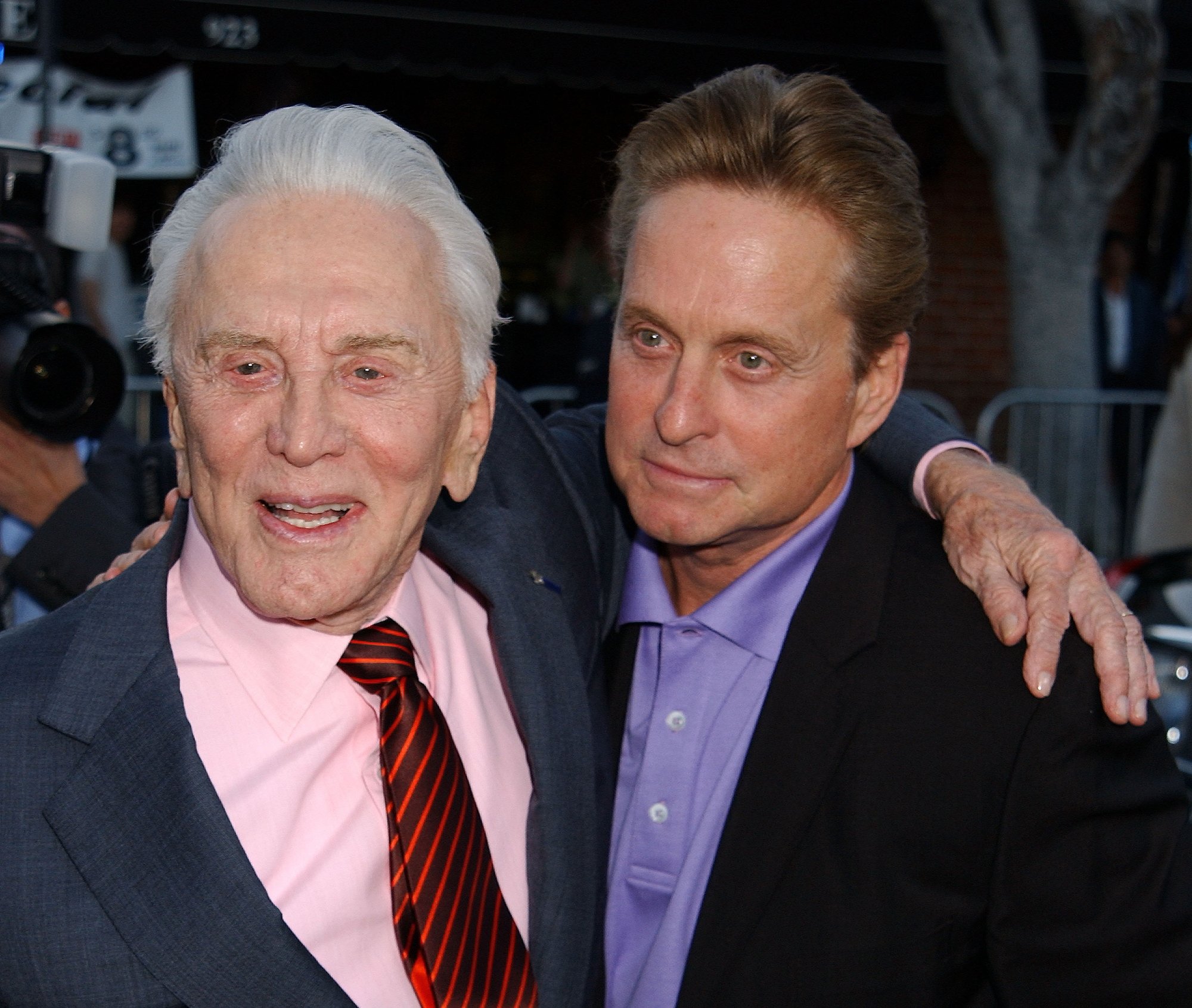 'One Flew Over the Cuckoo's Nest' Kirk Douglas and Michael Douglas. Kirk has his arm around Michael with them both wearing suits.