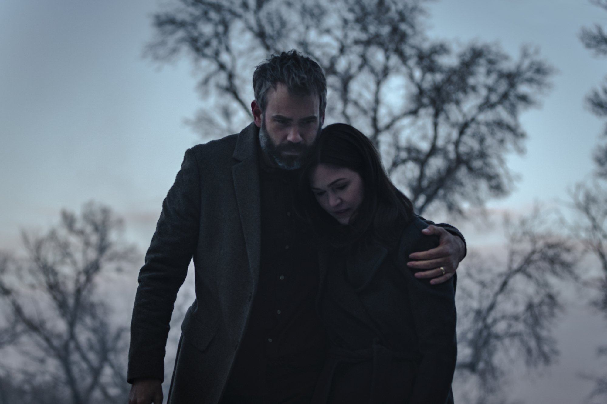 'Orphan: First Kill' ending Rossif Sutherland as Allen and Julia Stiles as Tricia holding one another outside with trees in the background