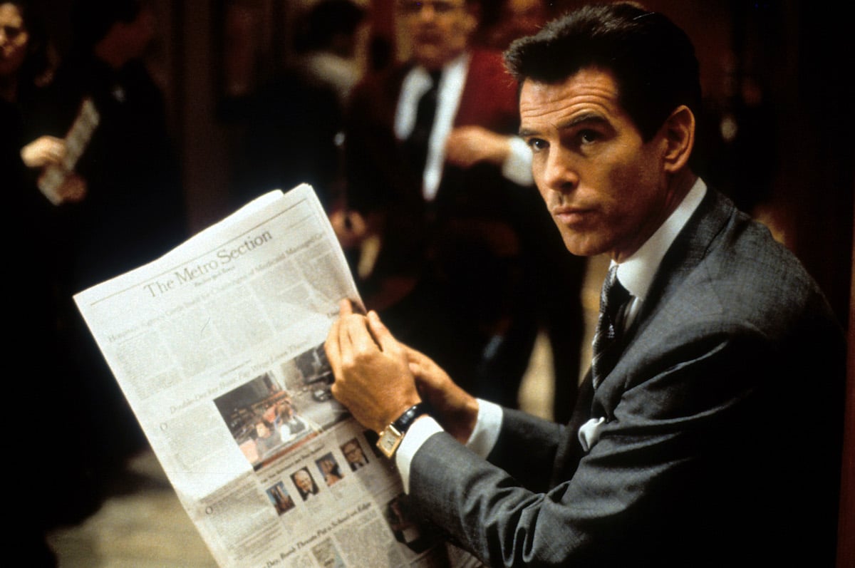 Pierce Brosnan, who picked the painting for the bowler hats scene, reads a newspaper in 'The Thomas Crown Affair'