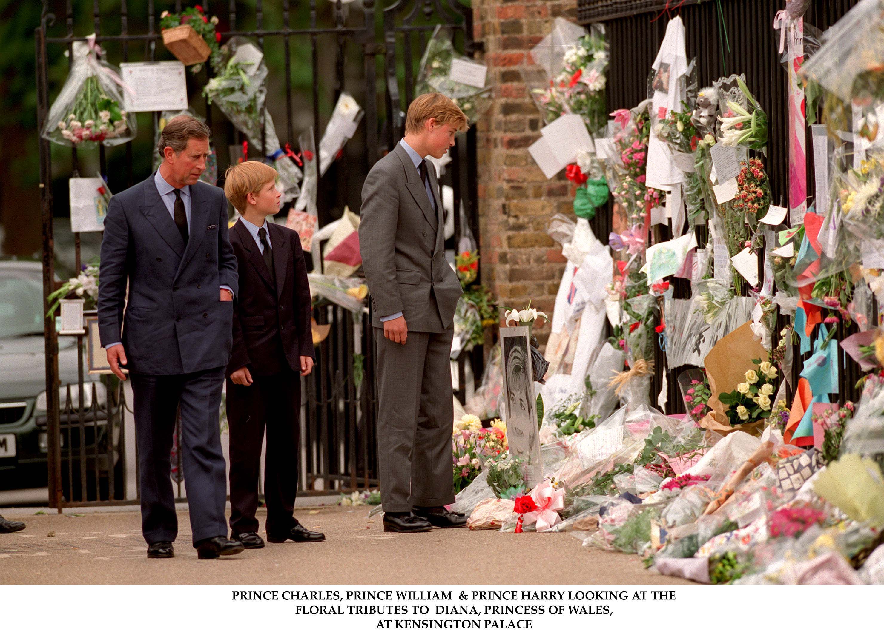 Prince Charles, Prince Harry, and Prince William viewing flower tributes to Princess Diana at Kensington Palace