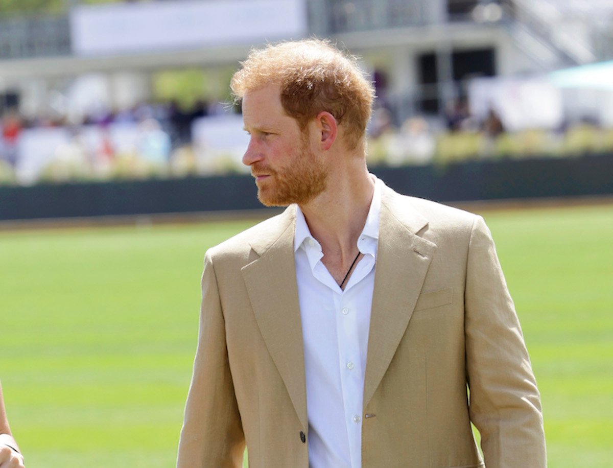 Prince Harry, whose memoir release date is reportedly 'up in the air,' looks on wearing a tan blazer and white shirt