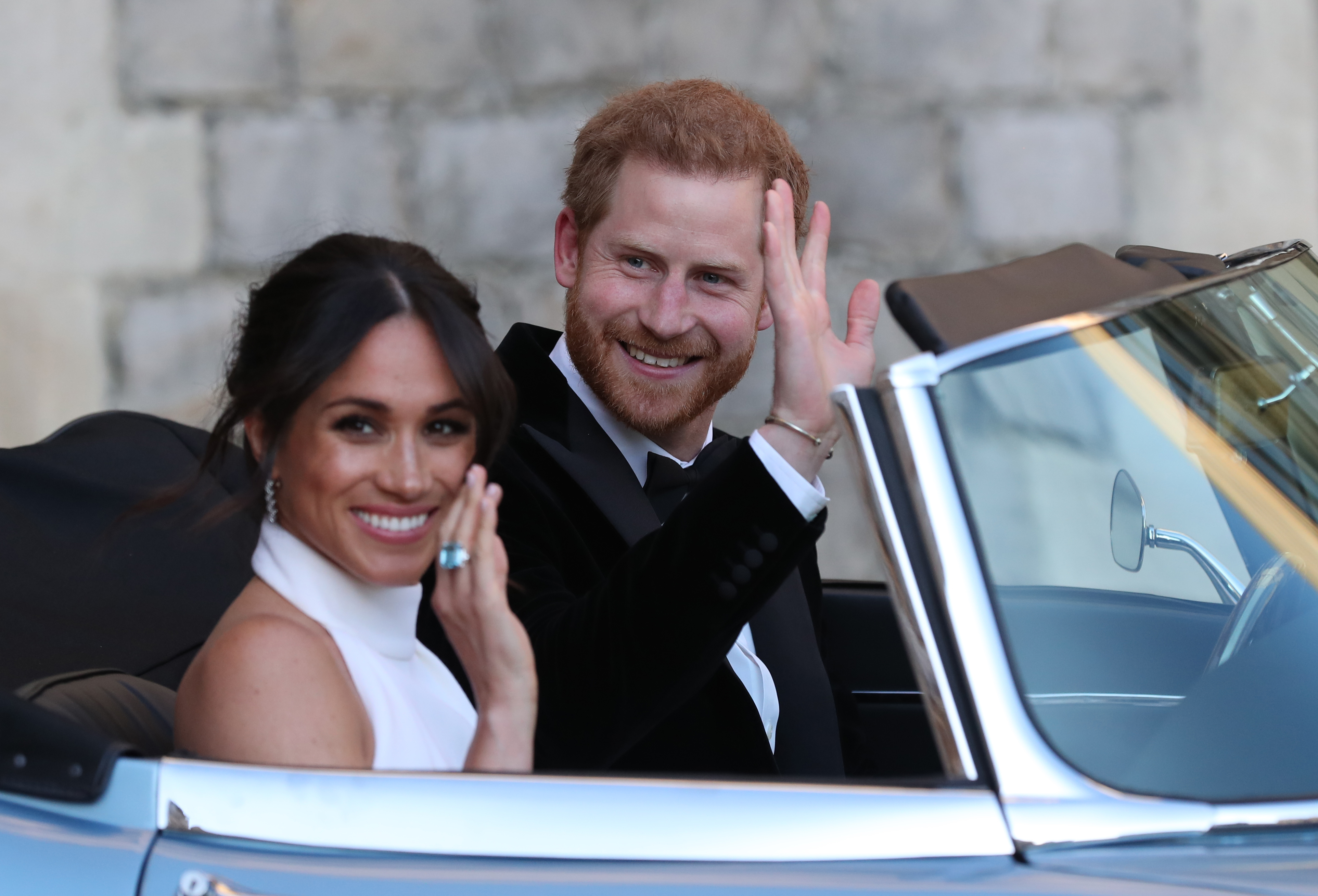 Prince Harry and Meghan Markle wave as they leave Windsor Castle after their wedding to attend an evening reception