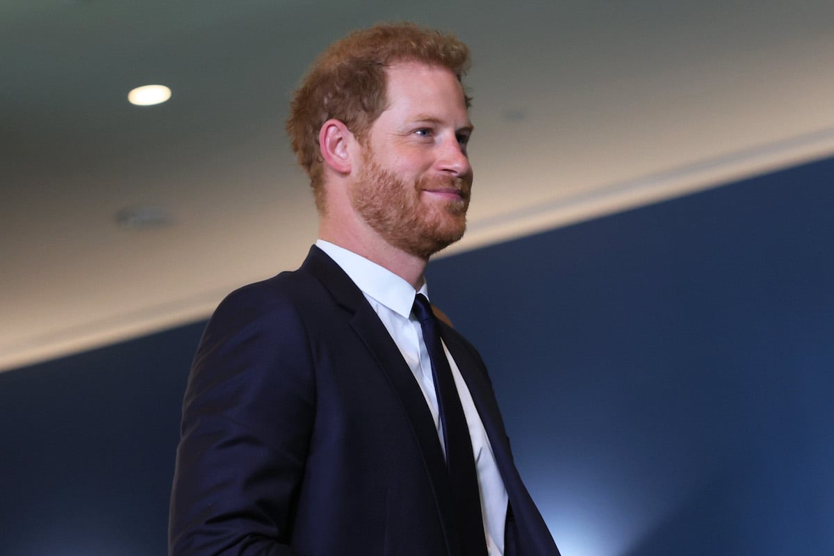 Prince Harry, whose memoir may be changed according to a journalist, looks on wearing a suit