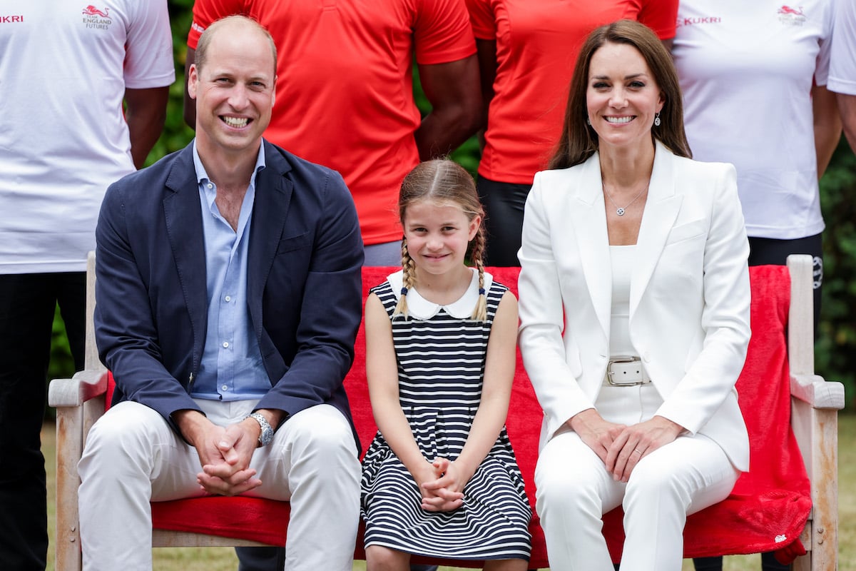 Princess Charlotte, who reached a 'turning point' in her relationship with Kate Middleton and Prince William at the Commonwealth Games according to a body language expert, sits in between Prince William and Kate Middleton