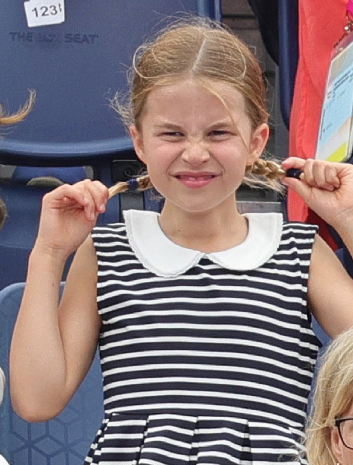 Princess Charlotte pulls on her pigtails while watching a match during Day 5 of the Commonwealth Games