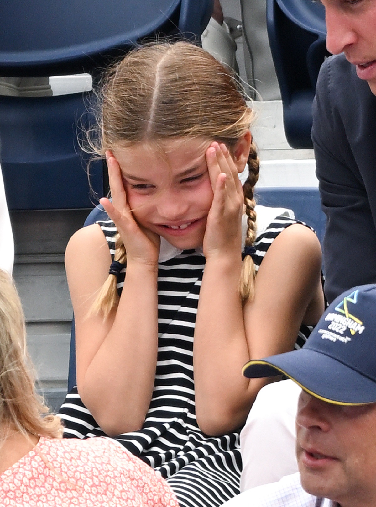 Princess Charlotte puts her hands to her face during a hockey match