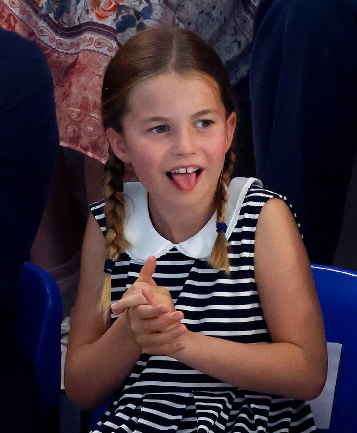 Princess Charlotte sticks out her tongue during swimming competition