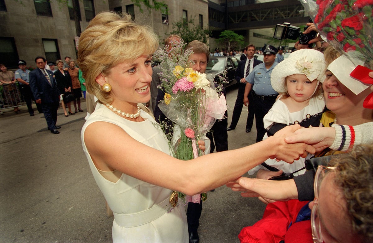 Princess Diana, whose death is the subject of 'The Diana Investigations' on discovery+, shakes hands with people