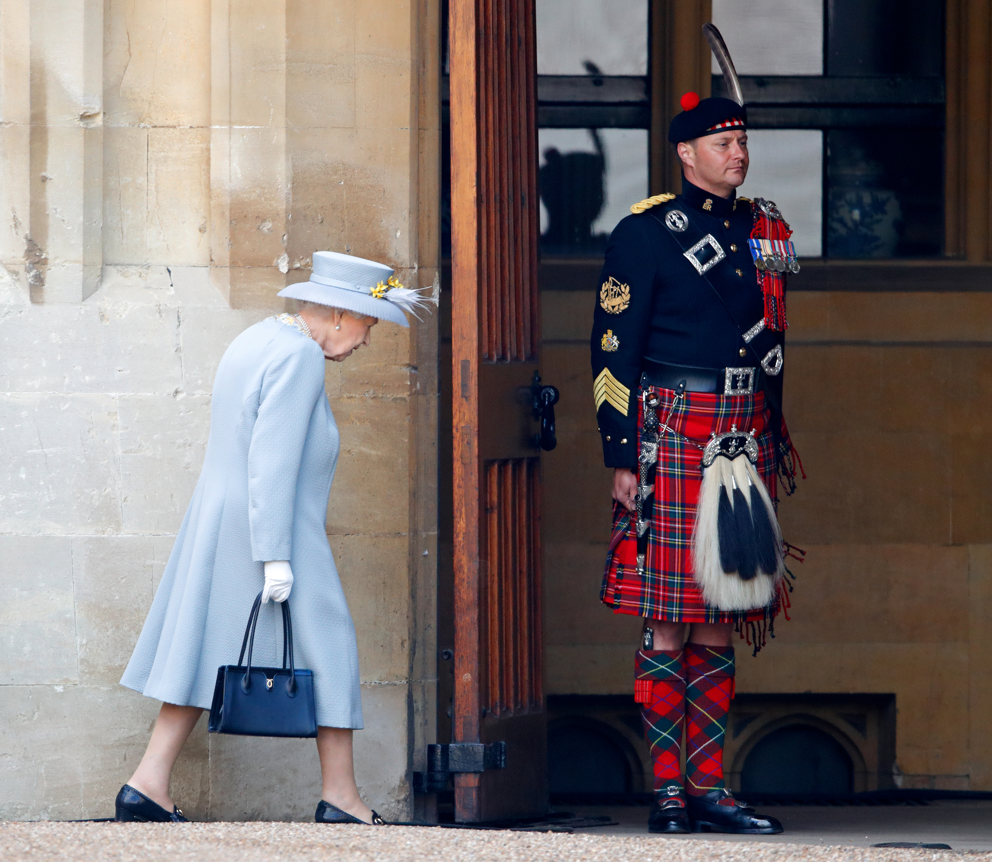 Queen Elizabeth II walks past her Piper, Major Richard Grisdale of The Royal Regiment of Scotland