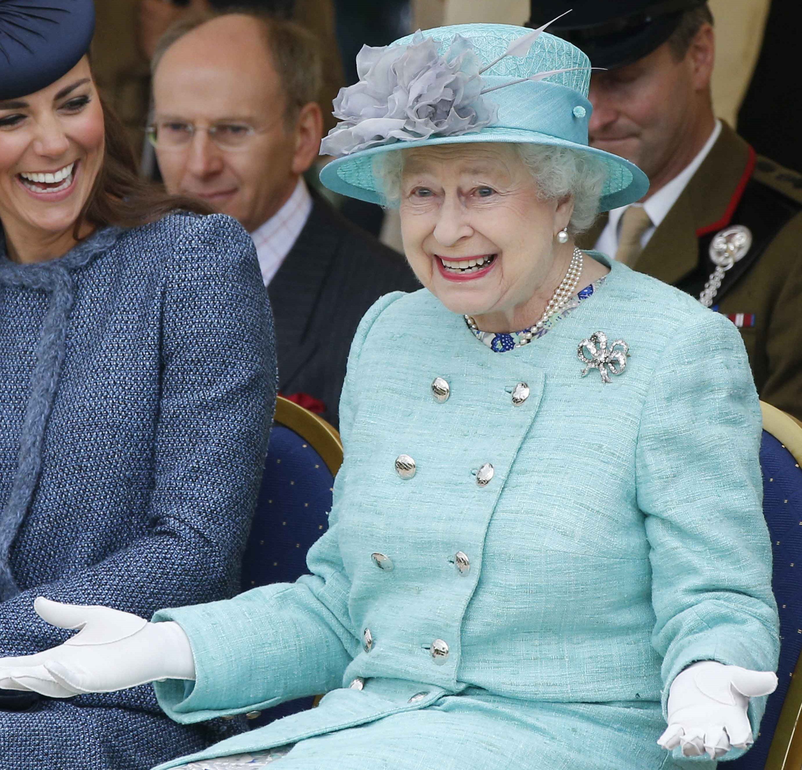 Queen Elizabeth II, whose bagpipers have received noise complaints, watching a children's sports event with Kate Middleton during a Diamond Jubilee visit