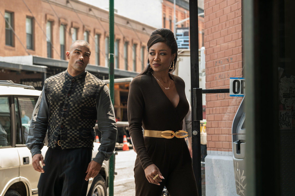 Patina Miller as Raq Thomas and Toby Sandeman as Symphony Bosket wearing shades of brown and walking down the street in 'Power Book III: Raising Kanan'