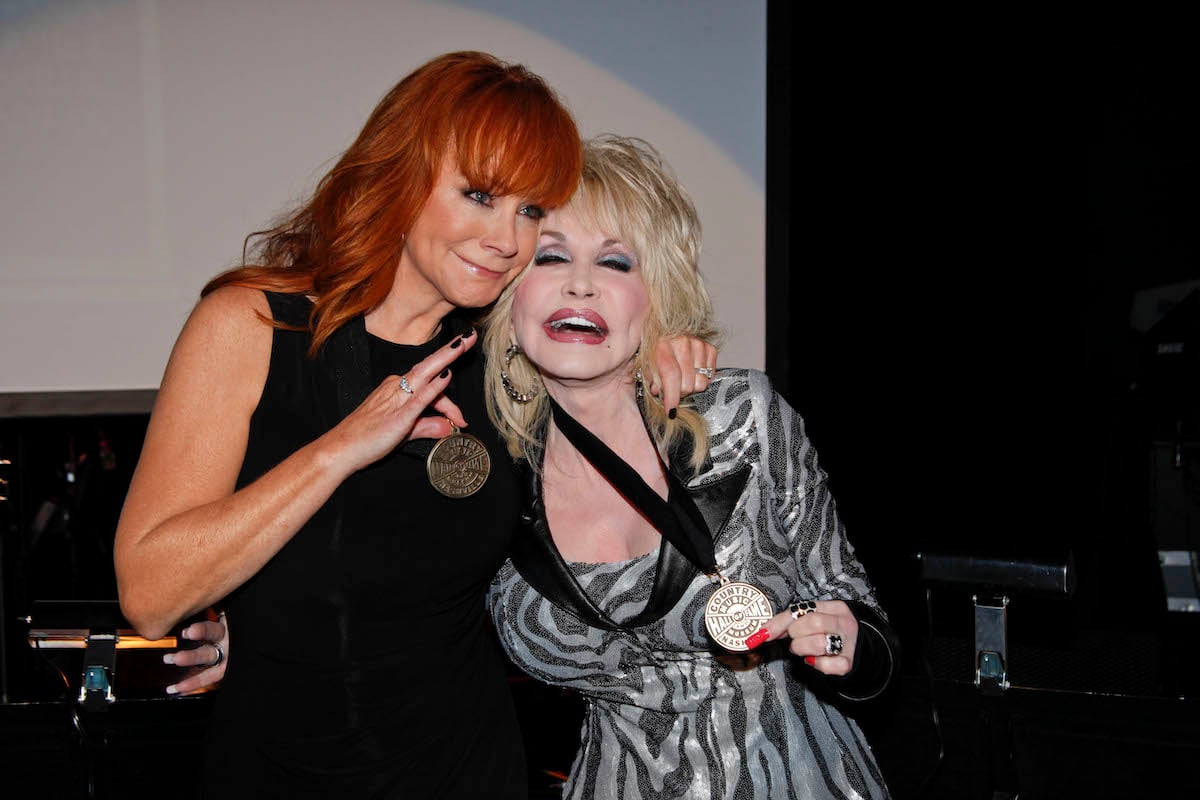 Reba McEntire and Dolly Parton smile together at the 2011 Country Music Hall of Fame Medallion Ceremony