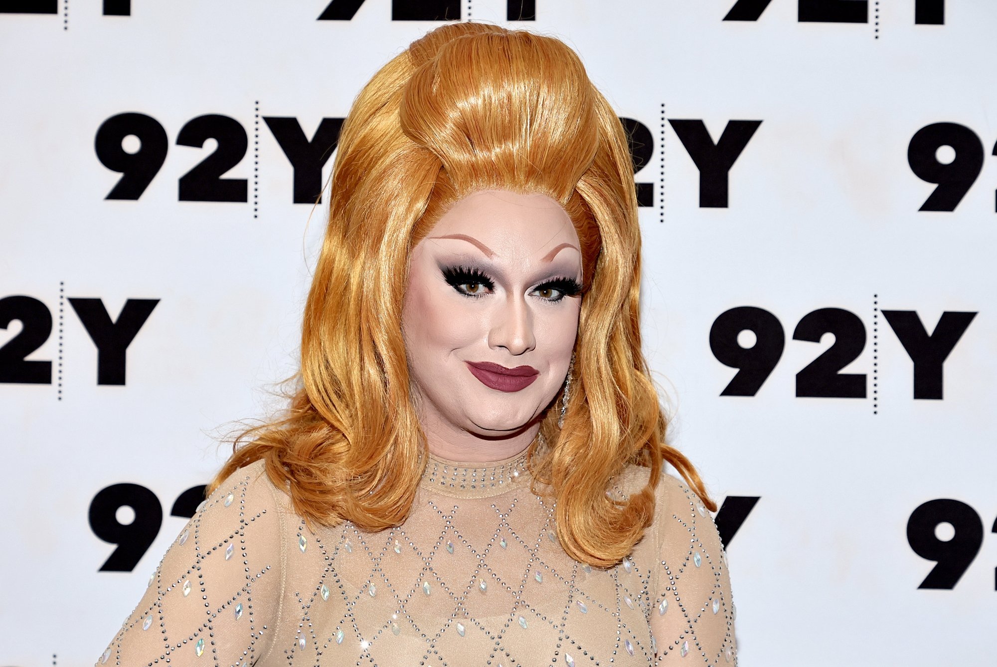 'RuPaul's Drag Race: All Stars 7' winner Jinkx Monsoon wearing a nude colored dress with orange hair in front of step and repeat