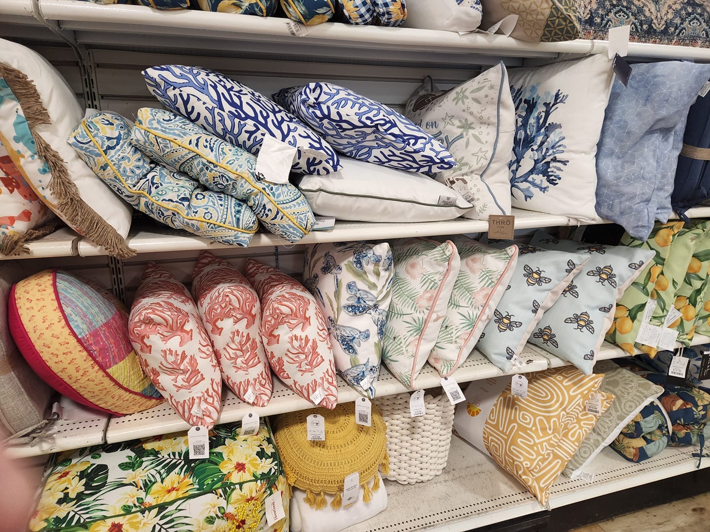 Craig Connover pillows lined on a shelf in a store .