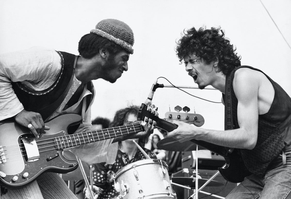 Santana band members David Brown (L) and Carlos Santana (R) performing onstage at Woodstock