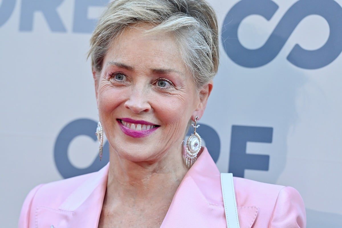 Sharon Stone smiling while wearing a pink blazer.