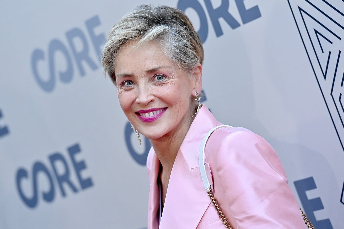 Sharon Stone smiling while wearing a pink suit.