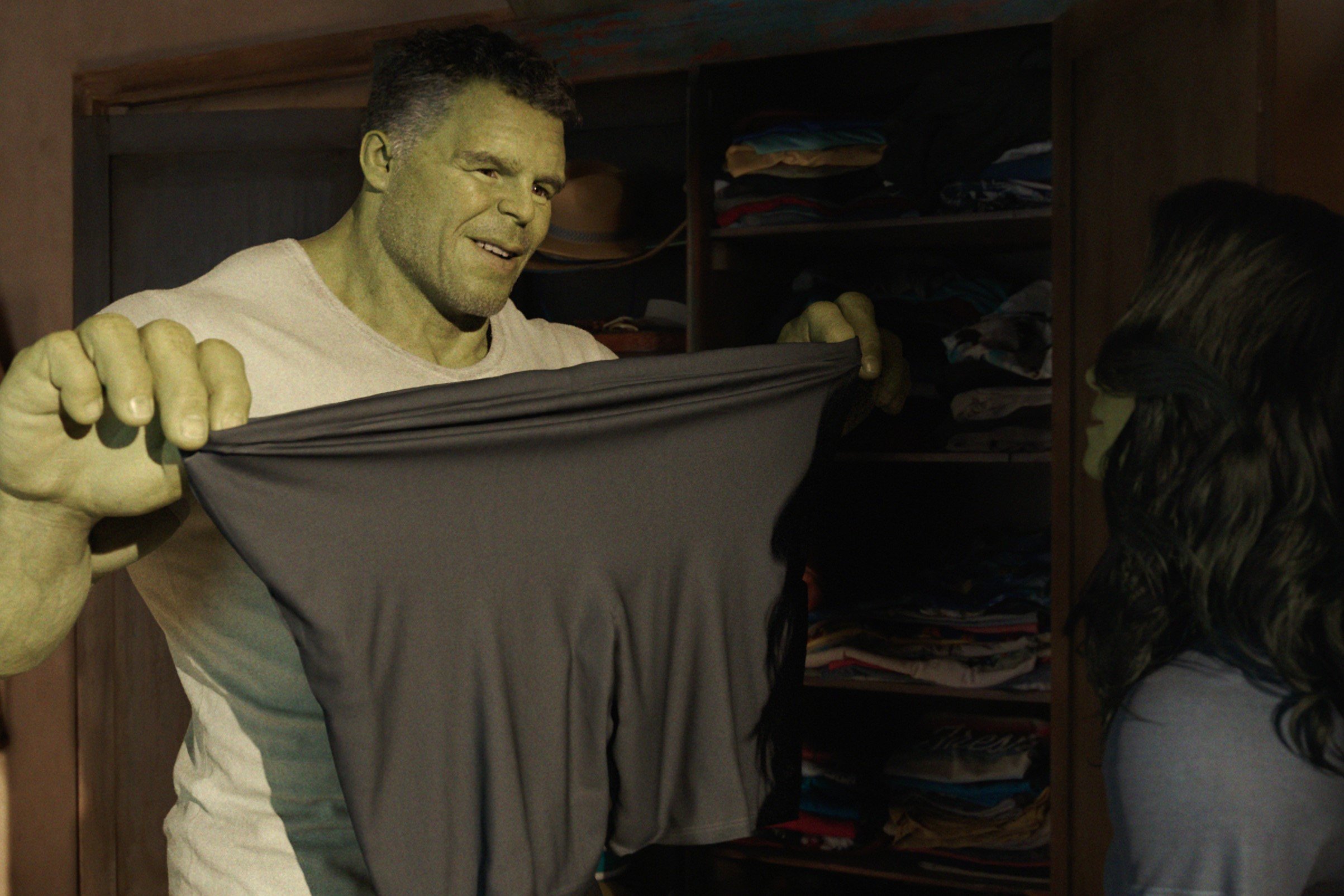Mark Ruffalo, in character as Bruce Banner/Hulk in 'She-Hulk: Attorney at Law' in the MCU, wears a white shirt and holds up a pair of gray shorts.