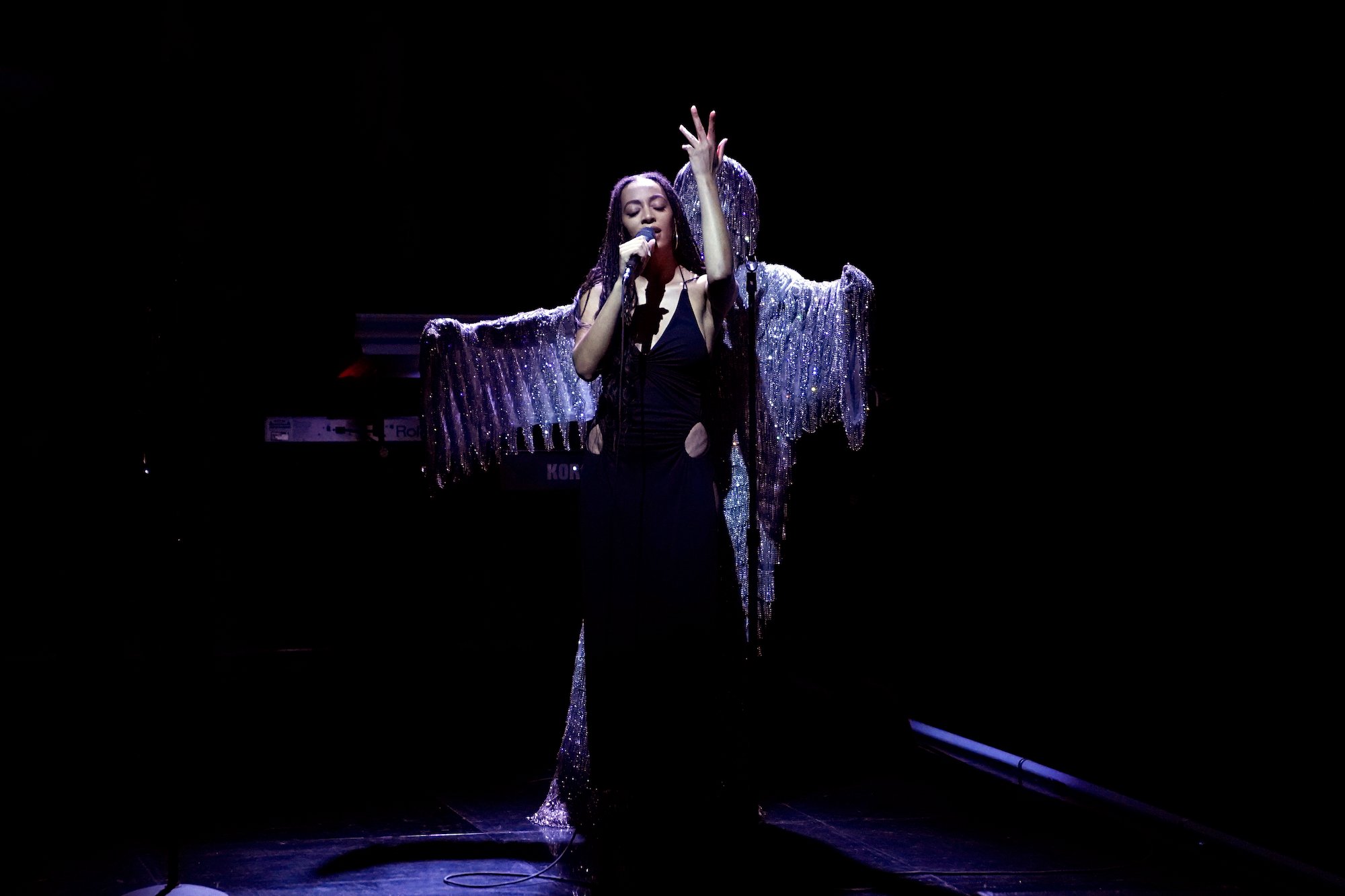 Solange, who is composing music for the NYC Ballet, performing in a black dress