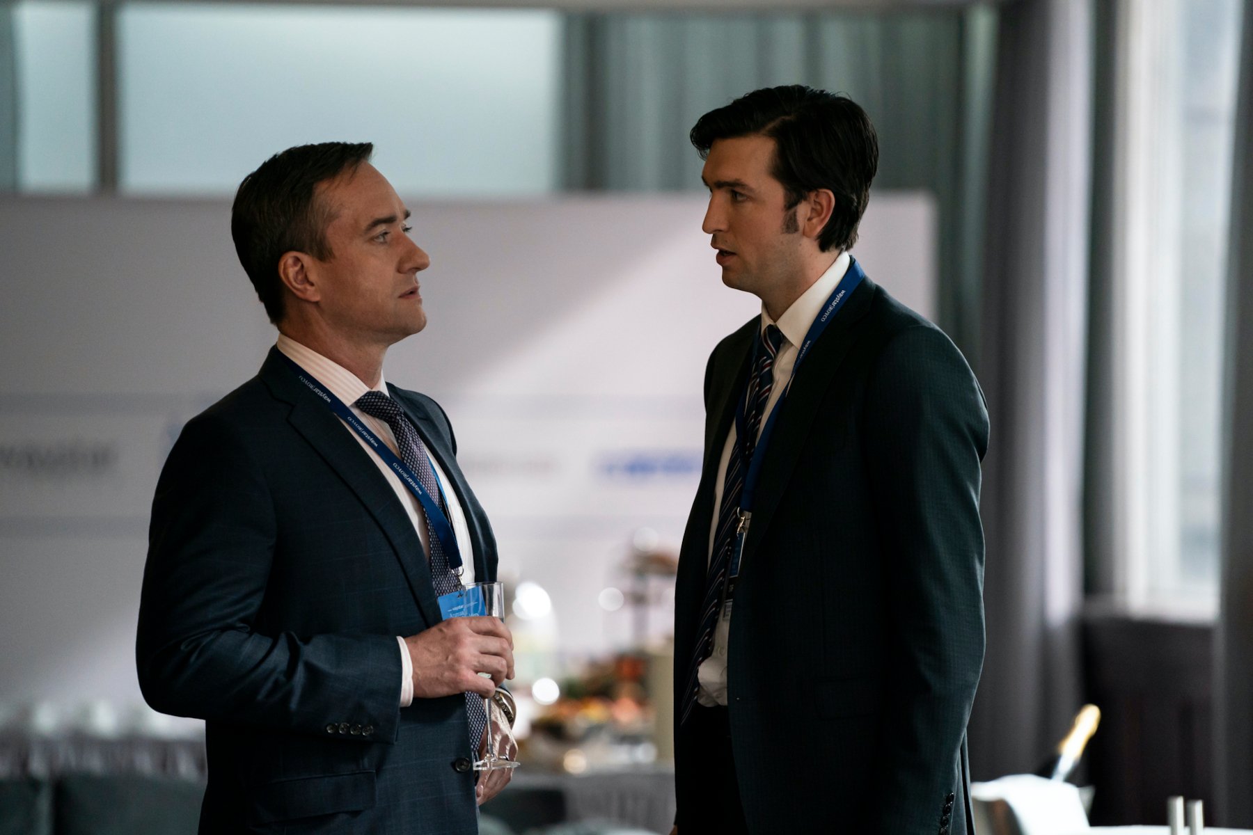 Matthew Macfadyen and Nicholas Braun as Tom and Cousin Greg in 'Succession' Season 3. They're both wearing suits and looking at one another.