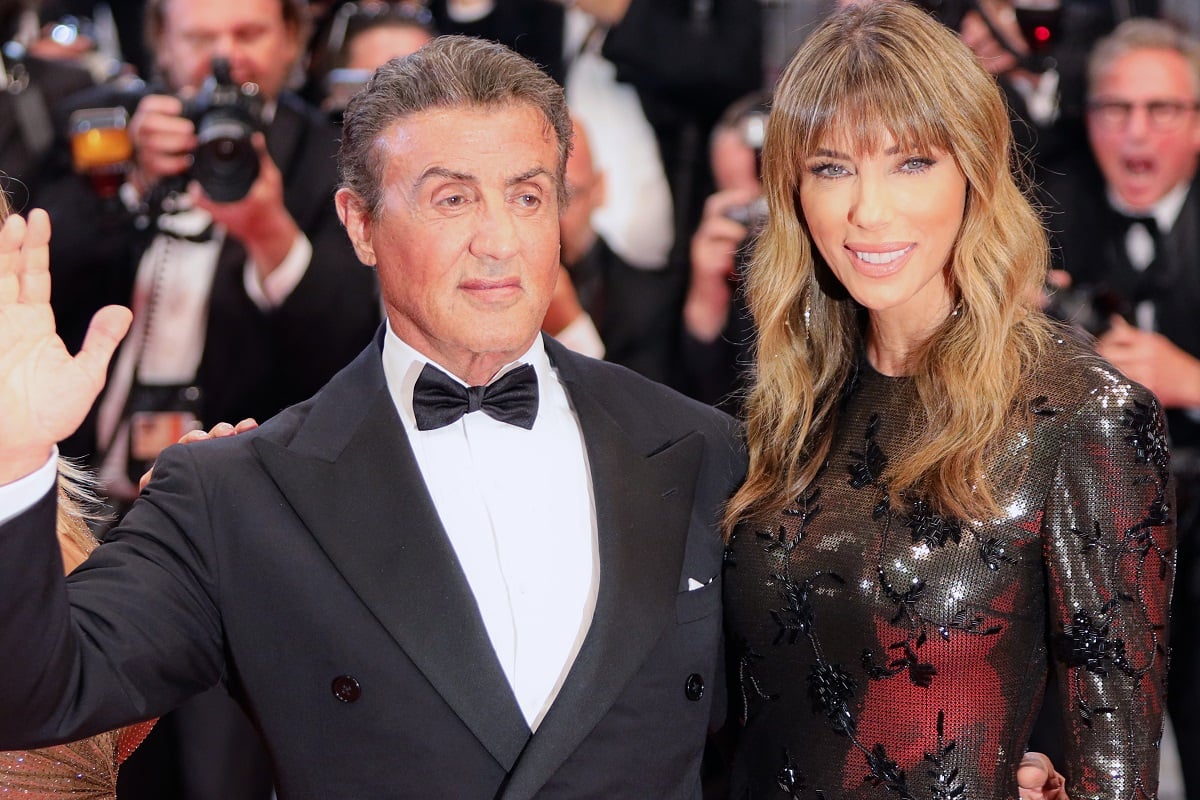 Sylvester Stallone and Jennifer Flavin, who has her own hefty net worth, smile on the red carpet at the screening of 'Rambo - First Blood'