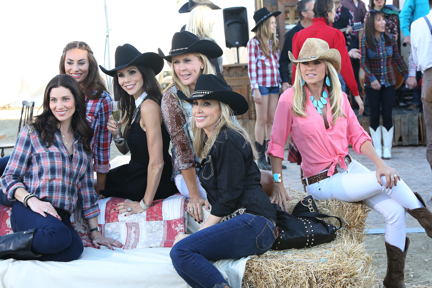 Danielle Gregorio, Lizzie Rovsek, Heather Dubrow, Vicki Gunvalson, Shannon Beador, Tamra Judge sit on large bales of hay and wear cowboy hats on 'RHOC'