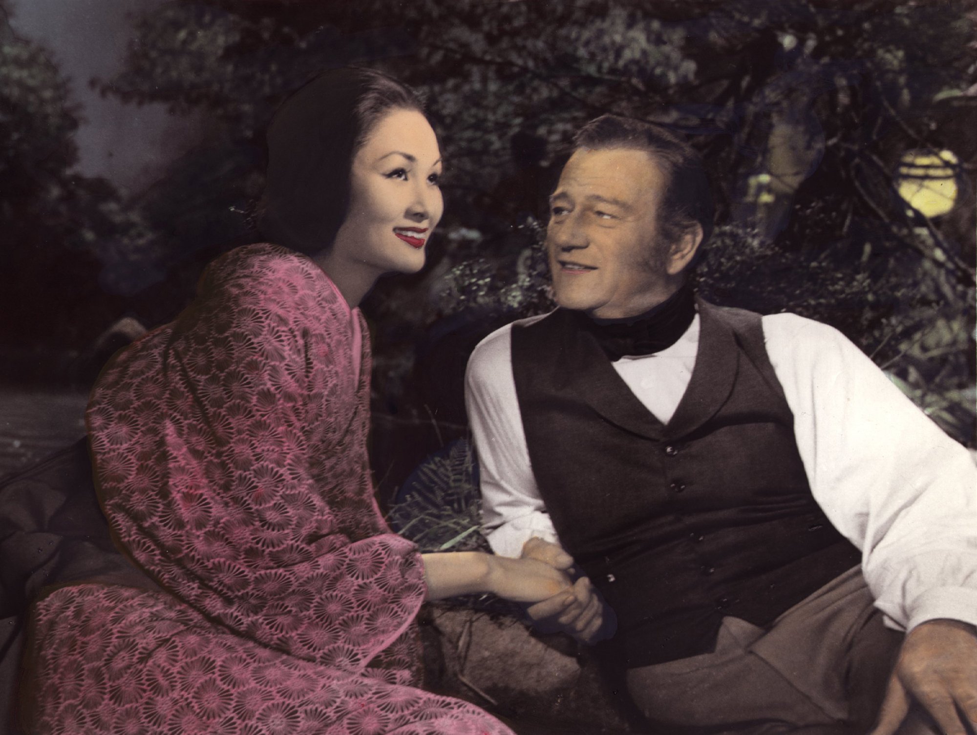 'The Barbarian and the Geisha' Eiko Ando as Okichi and John Wayne as Townsend Harris in a box office failure. Ando looking on with Wayne looking at her while holding her hand.
