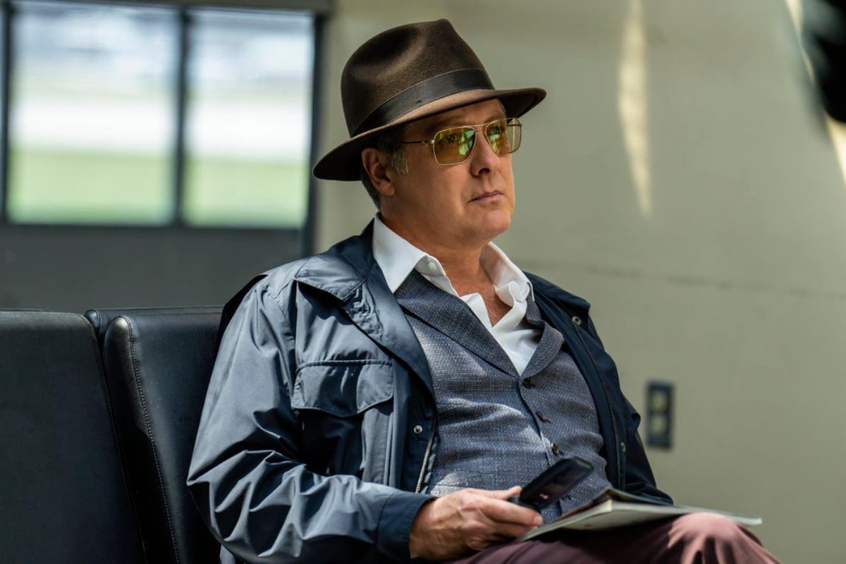 The Blacklist Season 10 will begin filming after Labor Day. Raymond Reddington sits at the airport holding a cellphone.