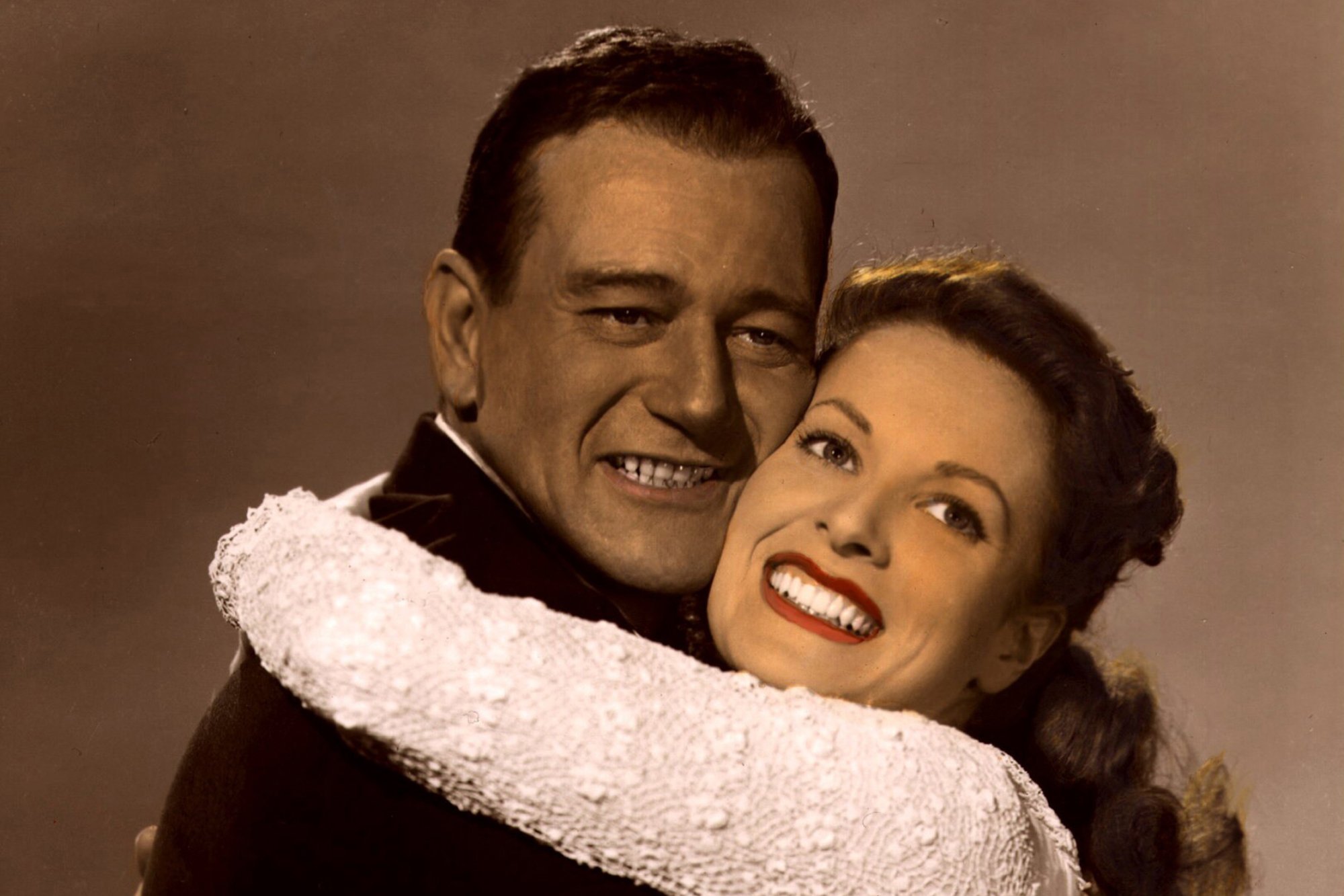 'The Quiet Man' John Wayne and Maureen O'Hara on the John Ford film. The two actors are smiling and hugging while looking at the camera.