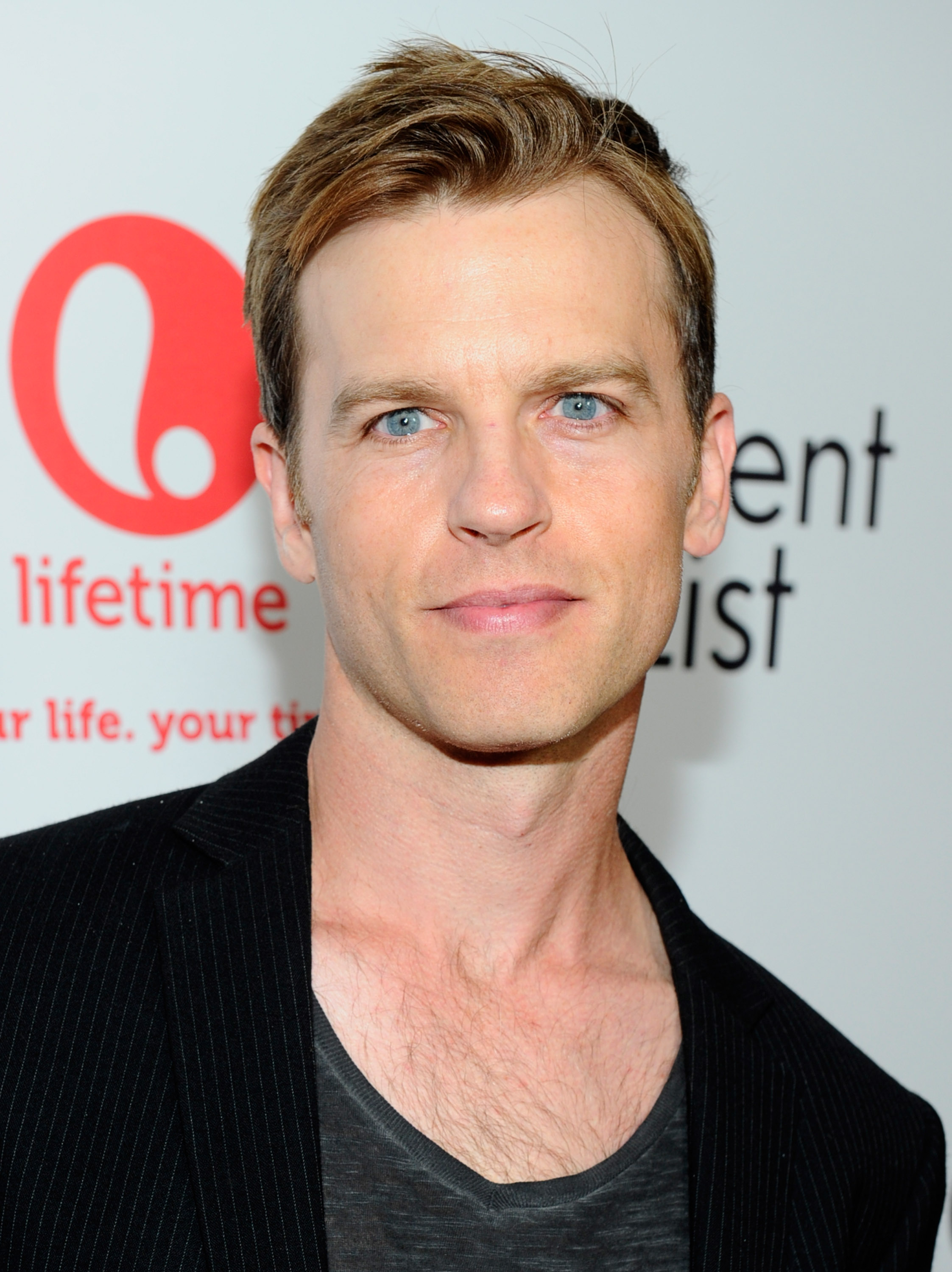 'The Young and the Restless' star Trevor St. John wearing a grey shirt and black and white striped suit.