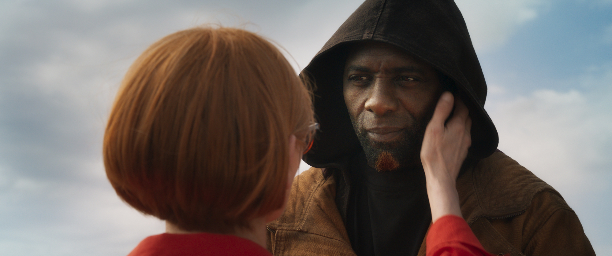 'Three Thousand Years of Longing' Tilda Swinton as Alithea and Idris Elba as The Djinn in a hoodie with Swinton's hand on his cheek