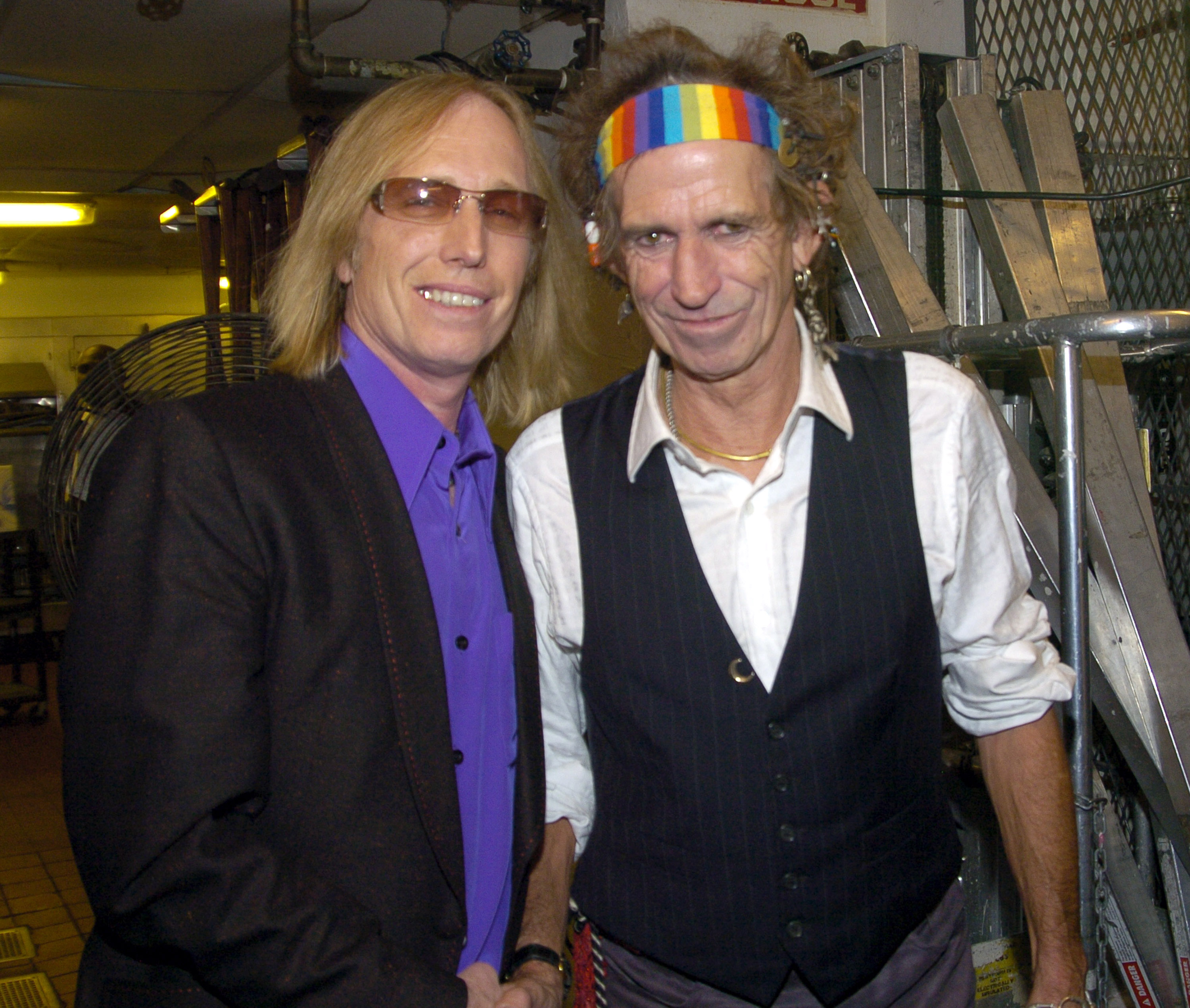 Tom Petty and Keith Richards pose together in a backstage space.