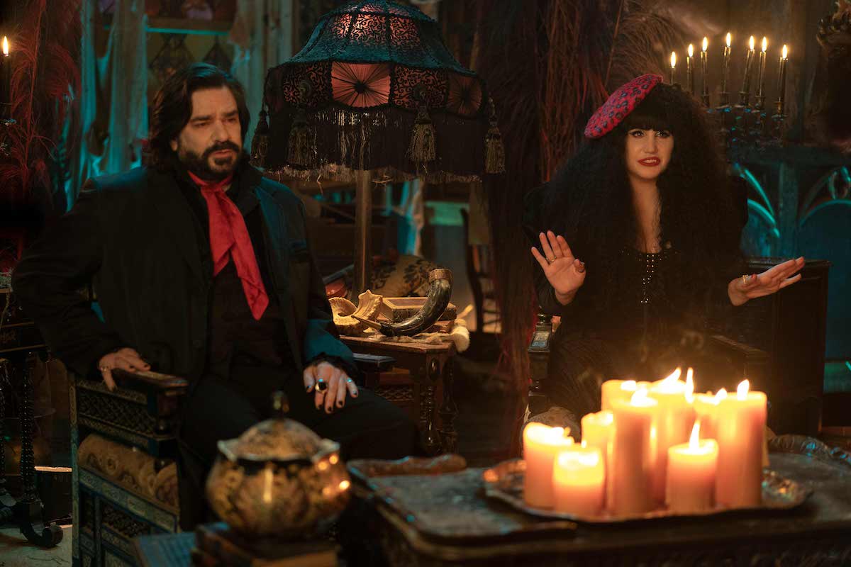 'What We Do in the Shadows' Season 4: Laszlo (Matt Berry) and Nadja (Natasia Demetriu) sit in chairs in front of candles