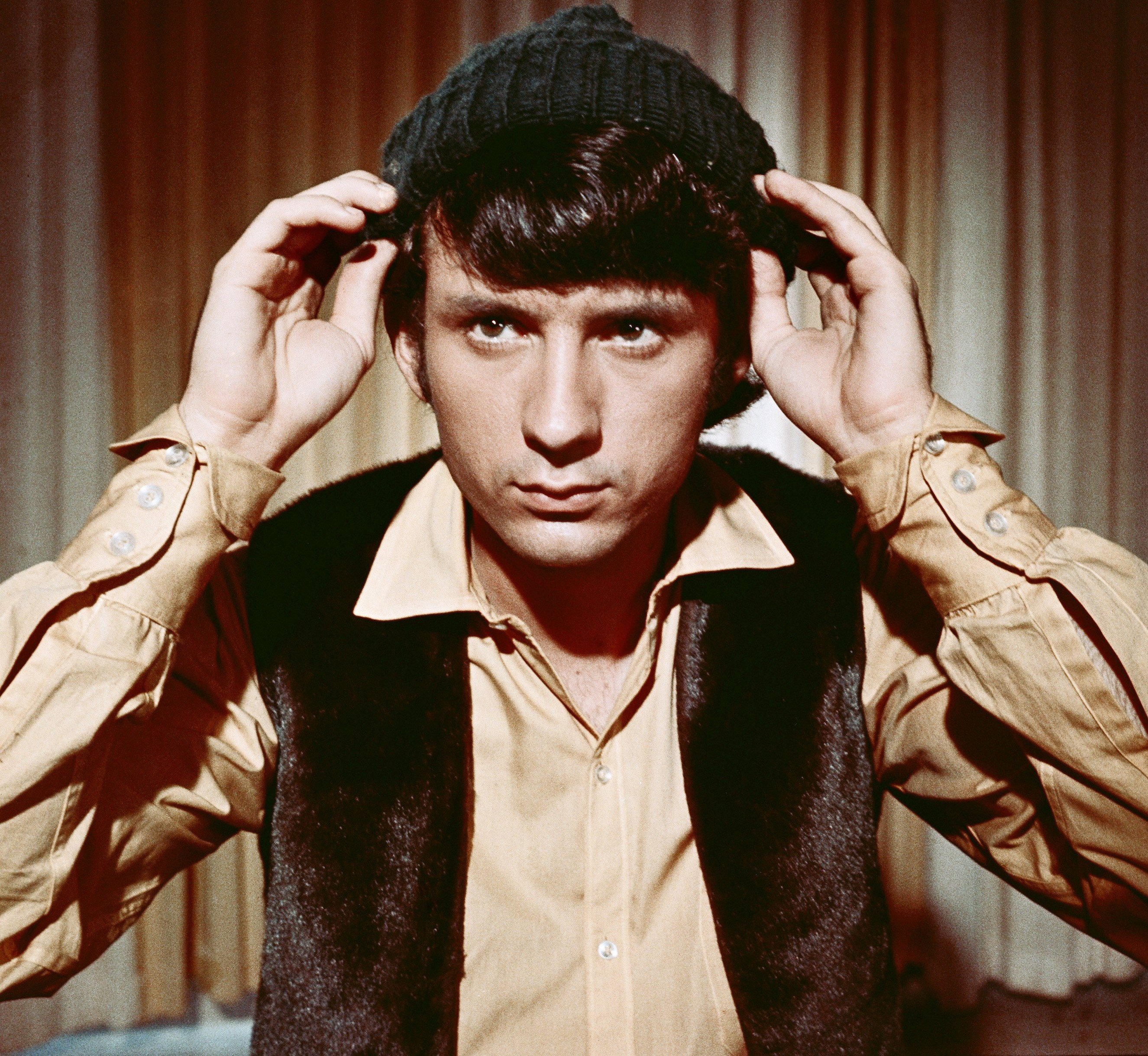 The Monkees' Mike Nesmith in front of a curtain