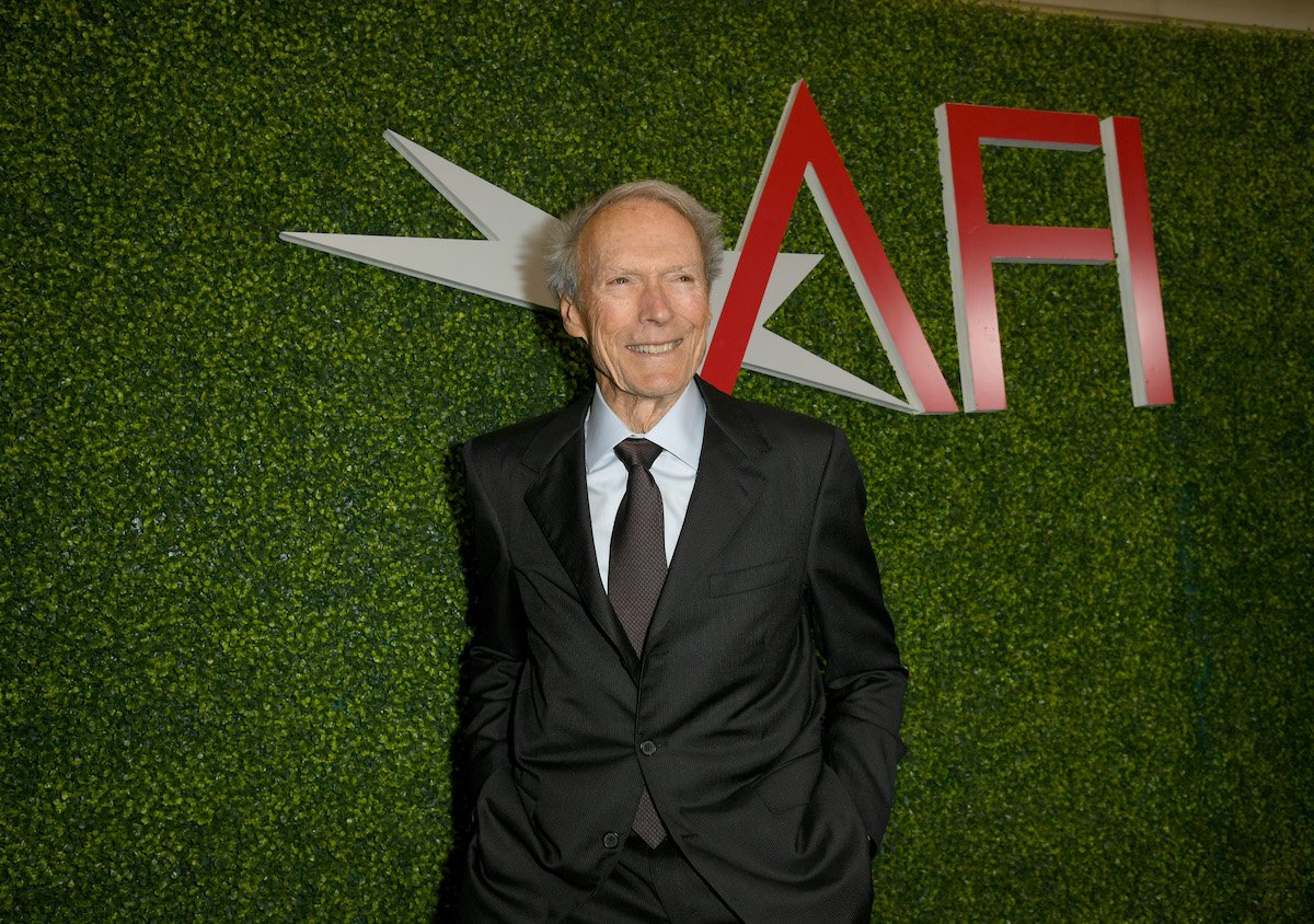 Clint Eastwood posing in front of a green AFI backdrop