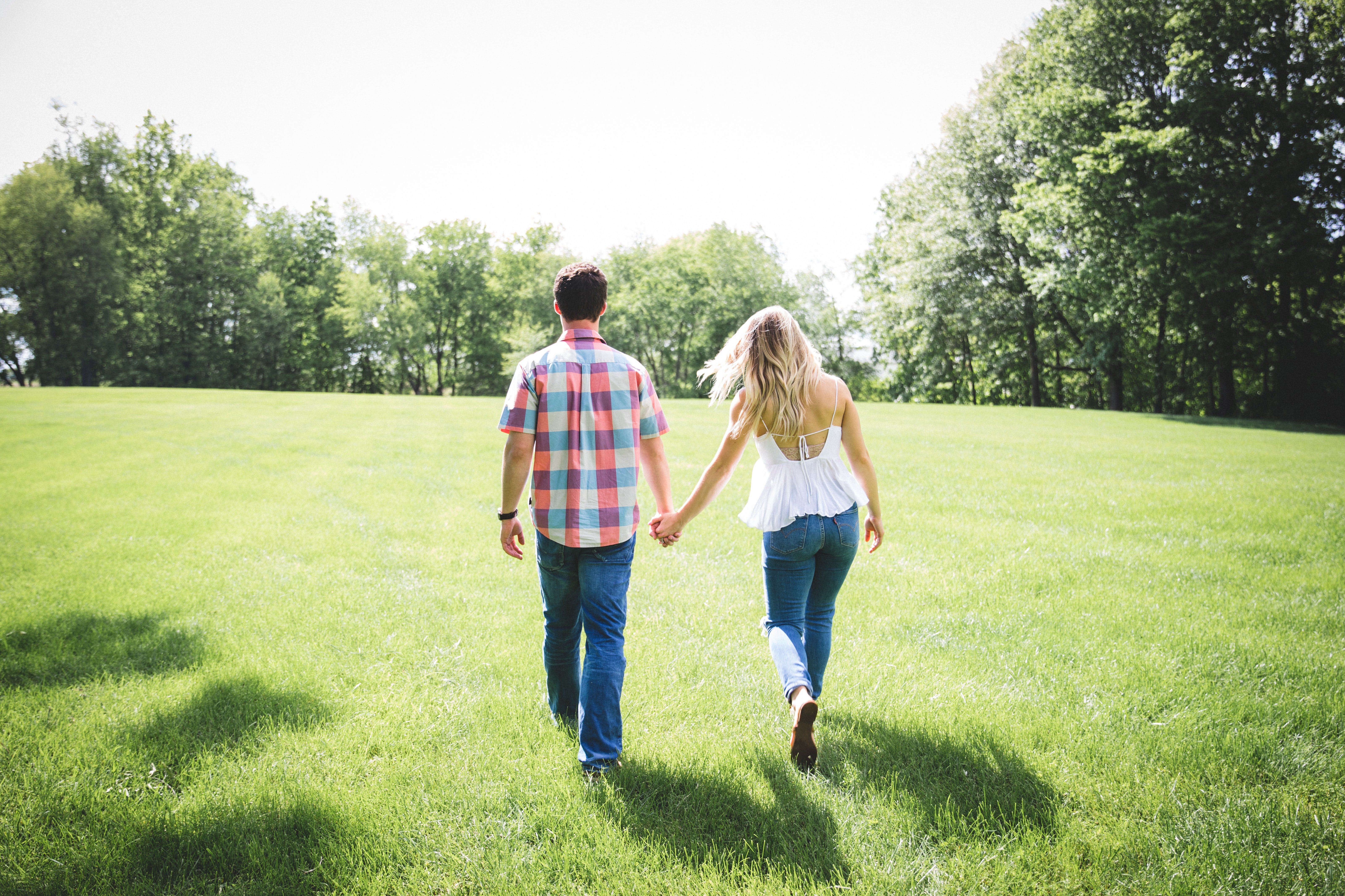 A couple holds hands while walking.