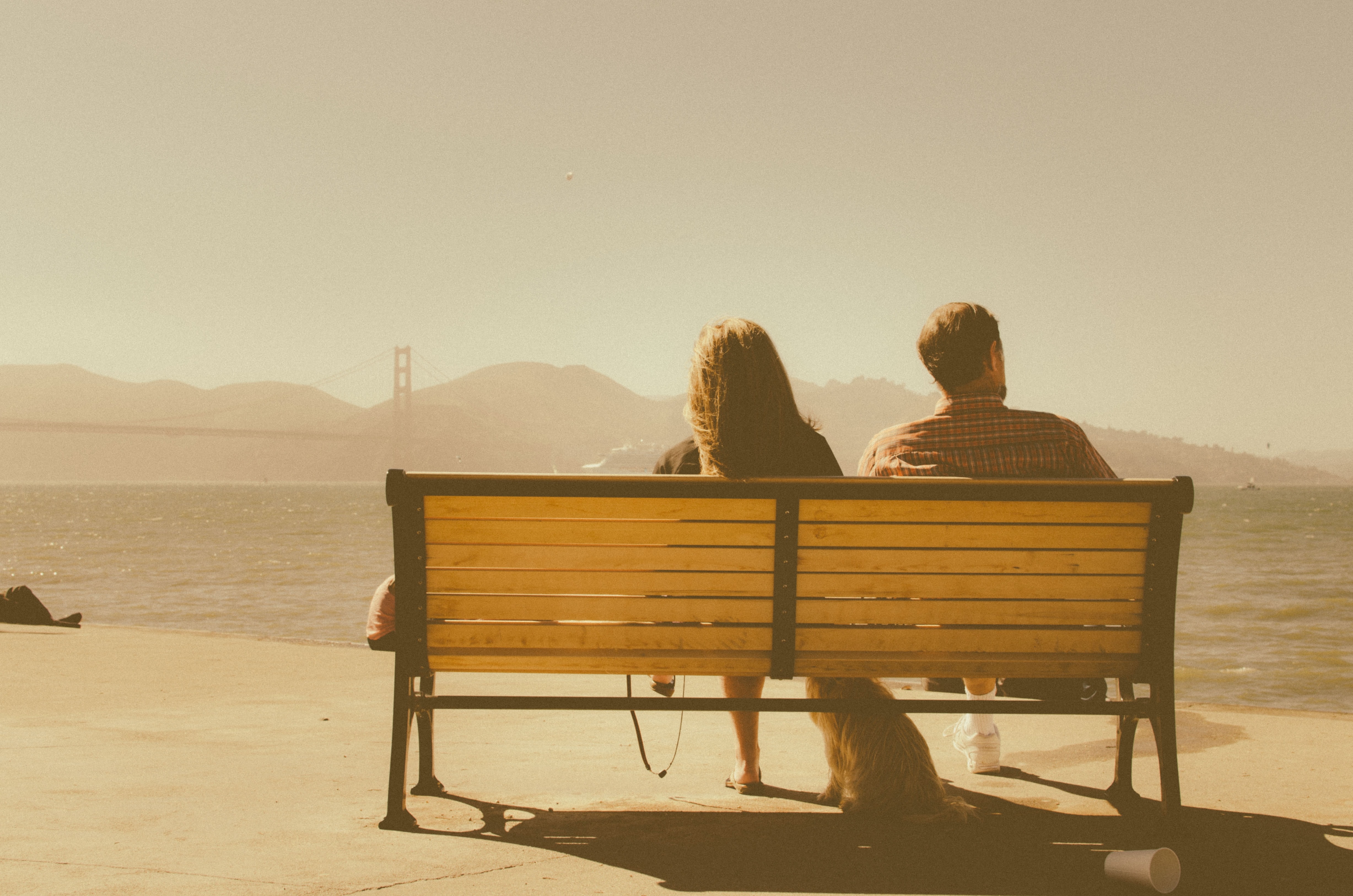 A couple sits on a bench.