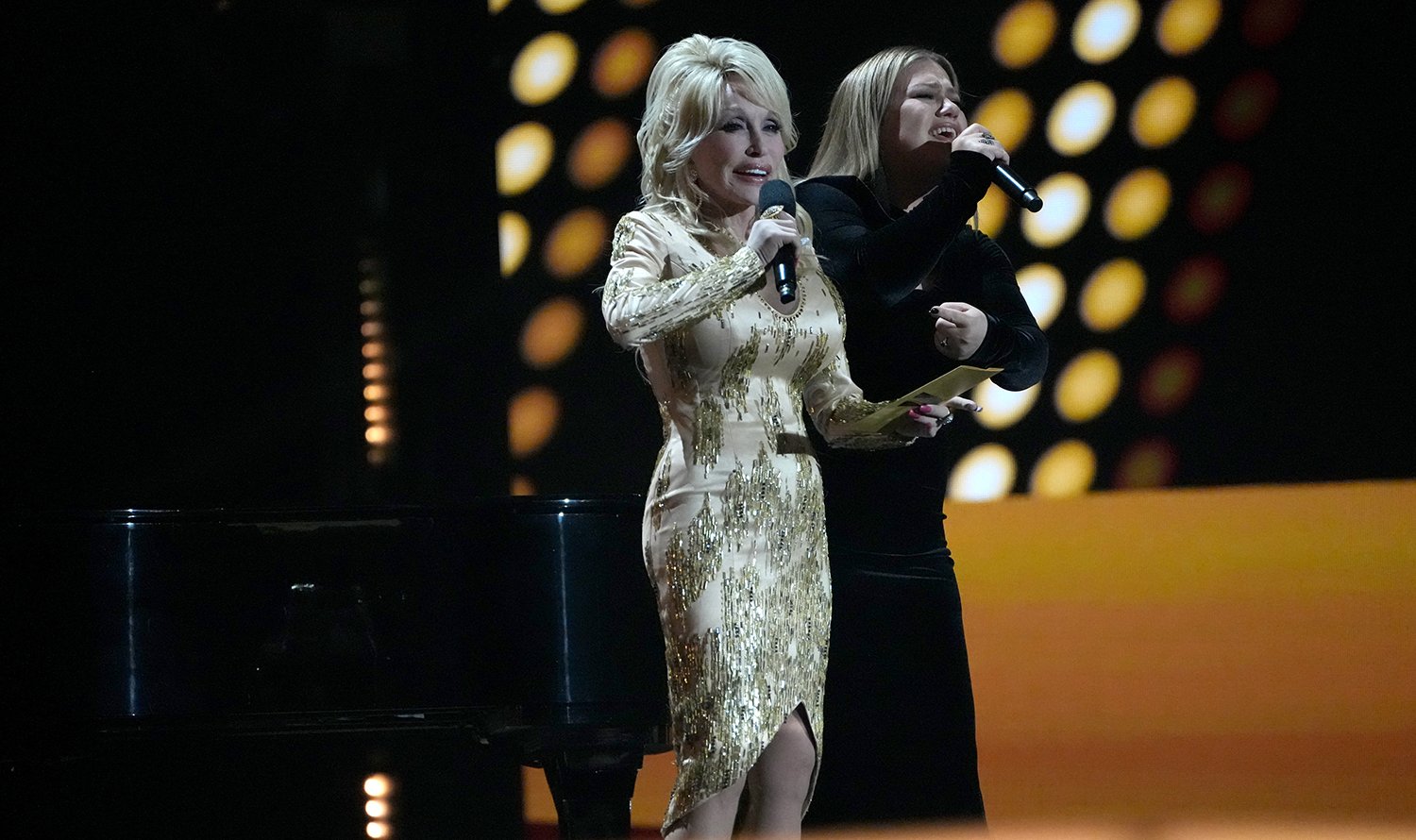 Dolly Parton and Kelly Clarkson, who have recorded a duet of Parton's 9 to 5, on stage together at the 57th Academy of Country Music Awards