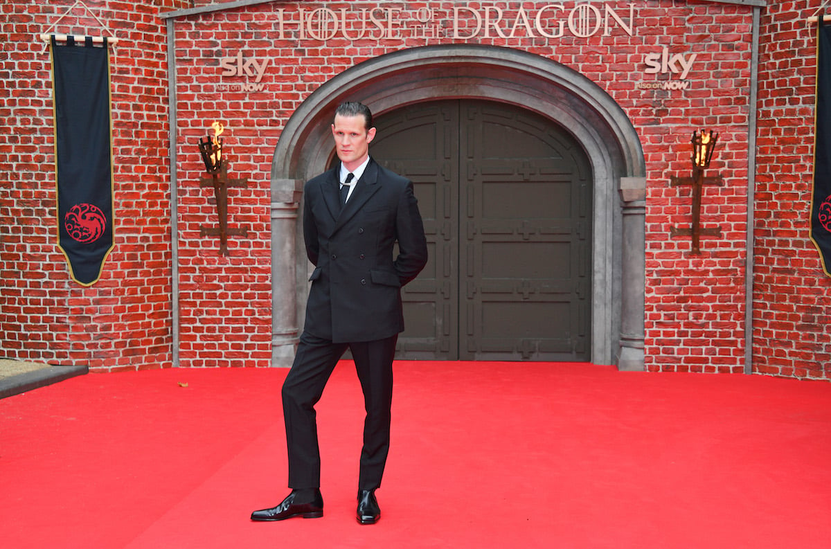 Matt Smith, whose net worth stands to rise thanks to 'House of the Dragon,' attends the premiere in London, posing on a red carpet in front of a brick backdrop.