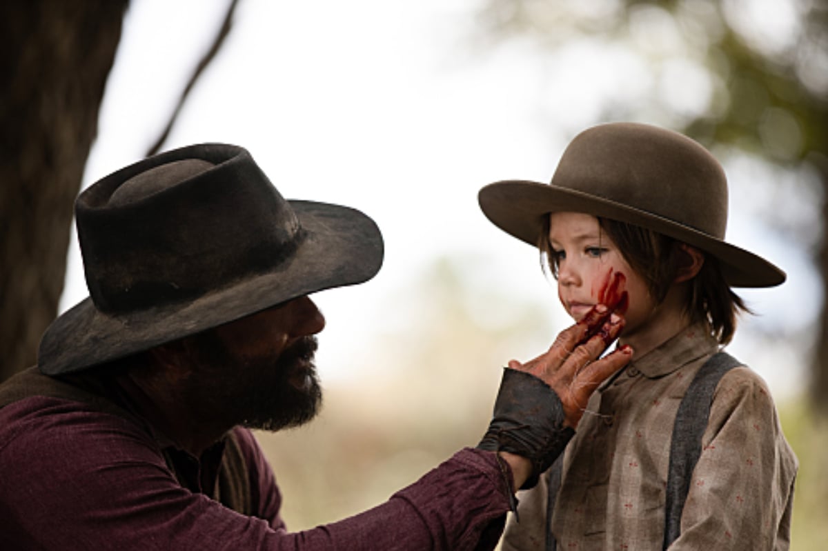 This scene from 1883 parallels a moment from Yellowstone. James smears deer blood on little John's face.