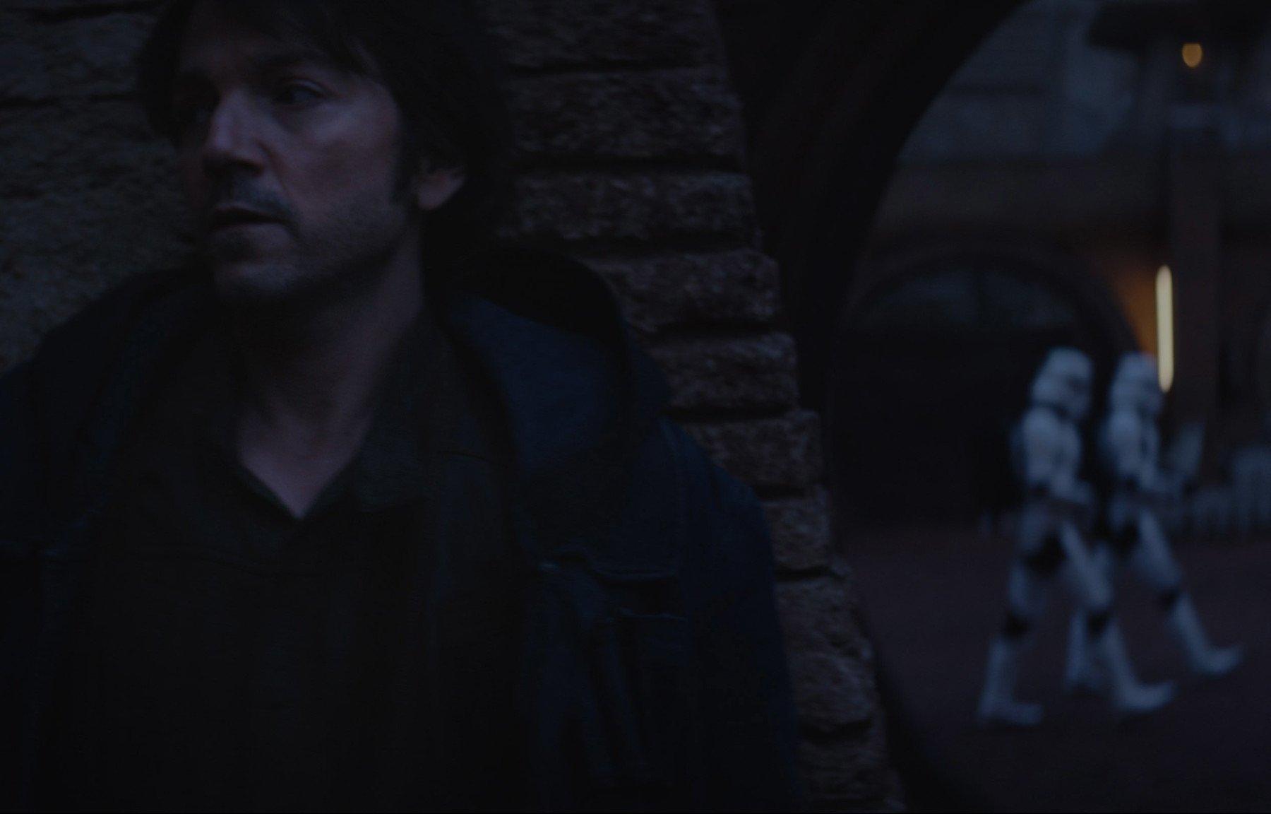 Diego Luna as Cassian Andor in 'Andor' for our article about episode 4's release date. He's hiding behind a wall while two Stormtroopers pass.