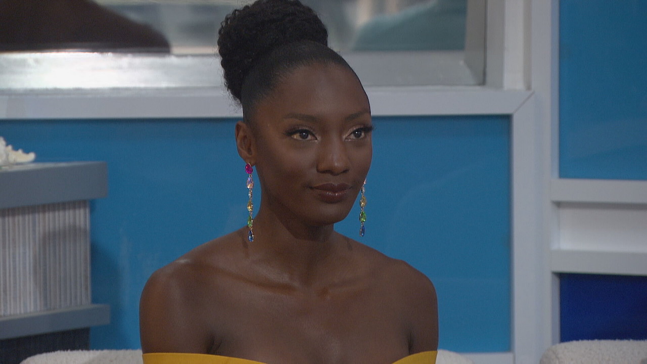 Azah Awasum sits in a yellow dress on Big Brother 23.