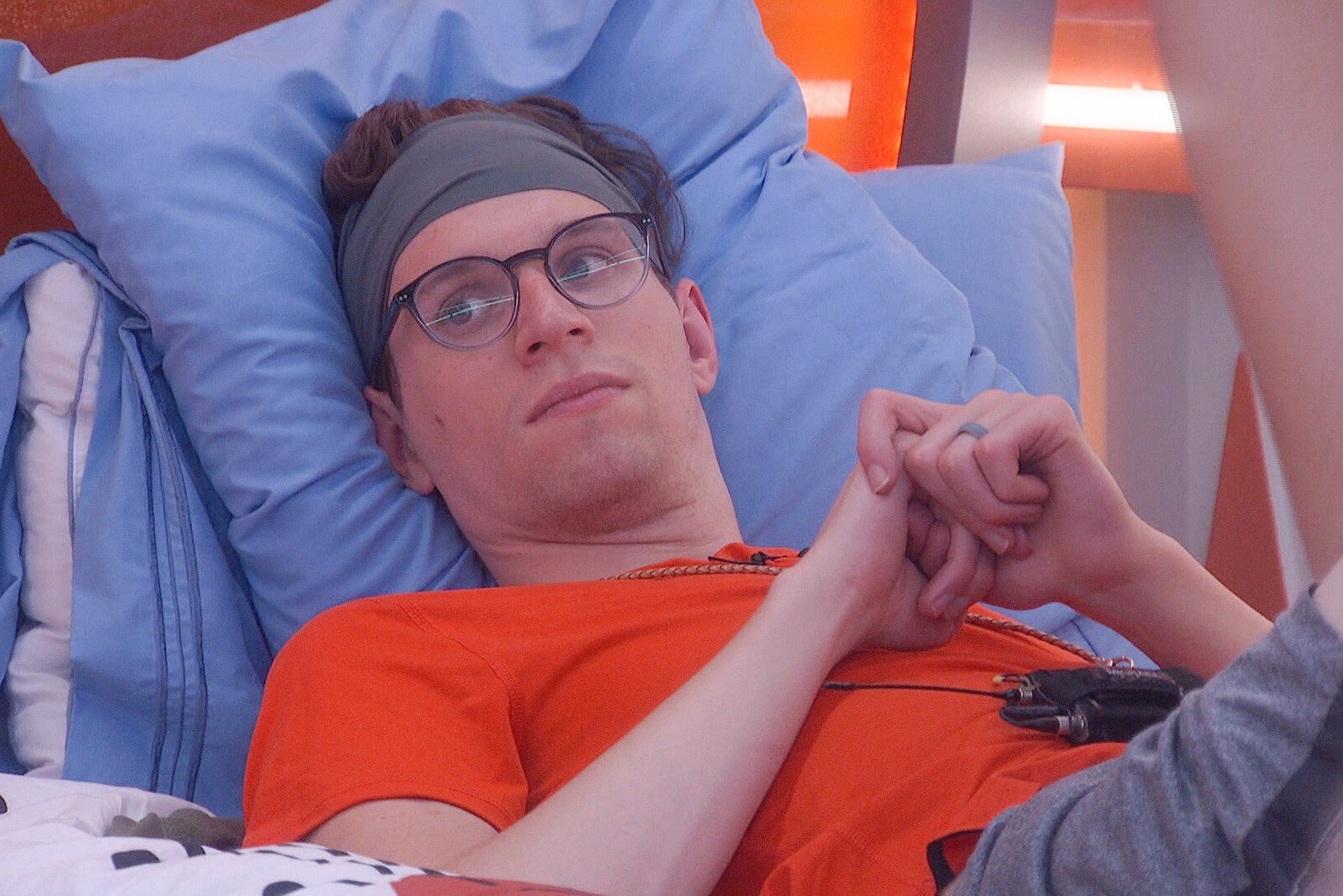 Michael Bruner, who stars in 'Big Brother 24' on CBS, wears an orange shirt, gray shorts, a gray headband, and glasses.