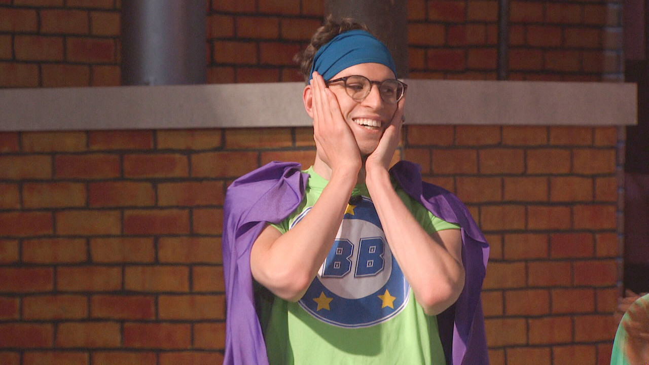 Michael Bruner is dressed with a cape for BB Comics and has his hands on his cheeks on 'Big Brother 24'.