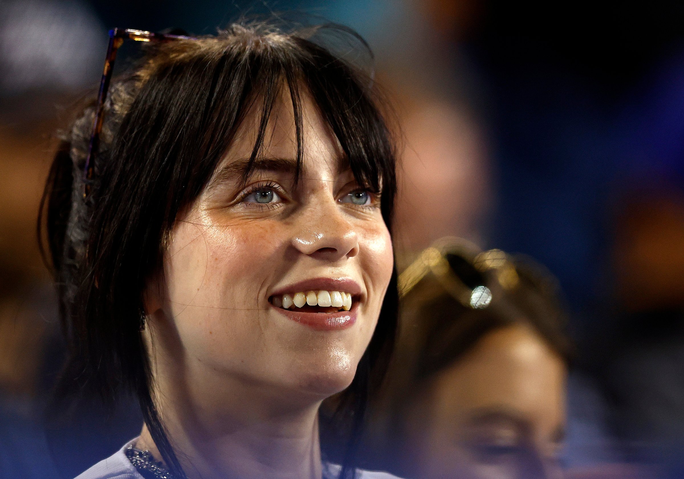 Billie Eilish, who had a fear of going outside, smiling at a baseball game.