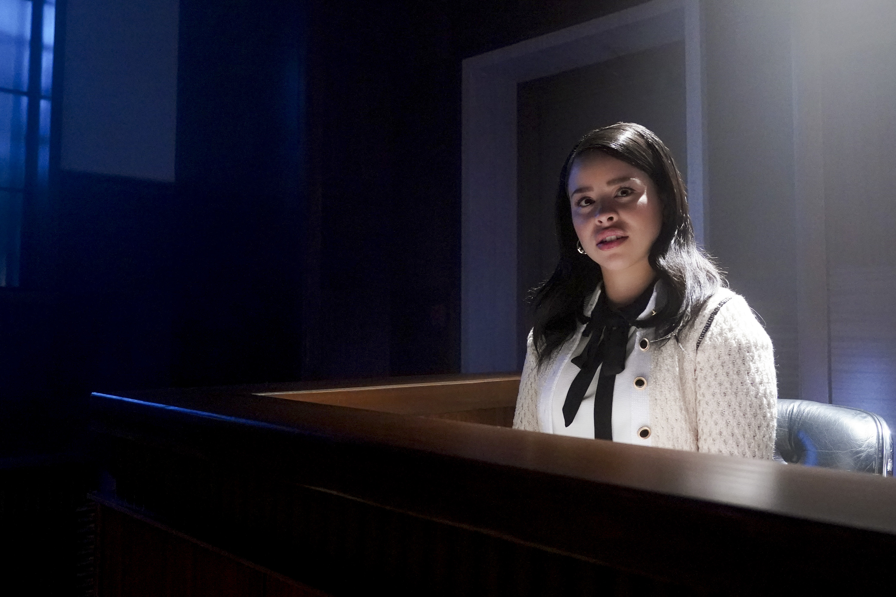 Cierra Ramirez wears a white shirt and white sweater as she sits in the witness stand in court.