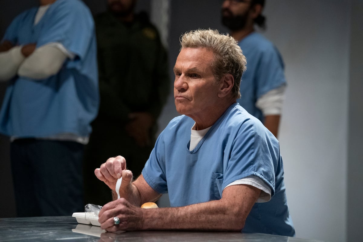 'Cobra Kai' Season 5: John Kreese (Martin Kove) sits in the prison mess hall holding utensils