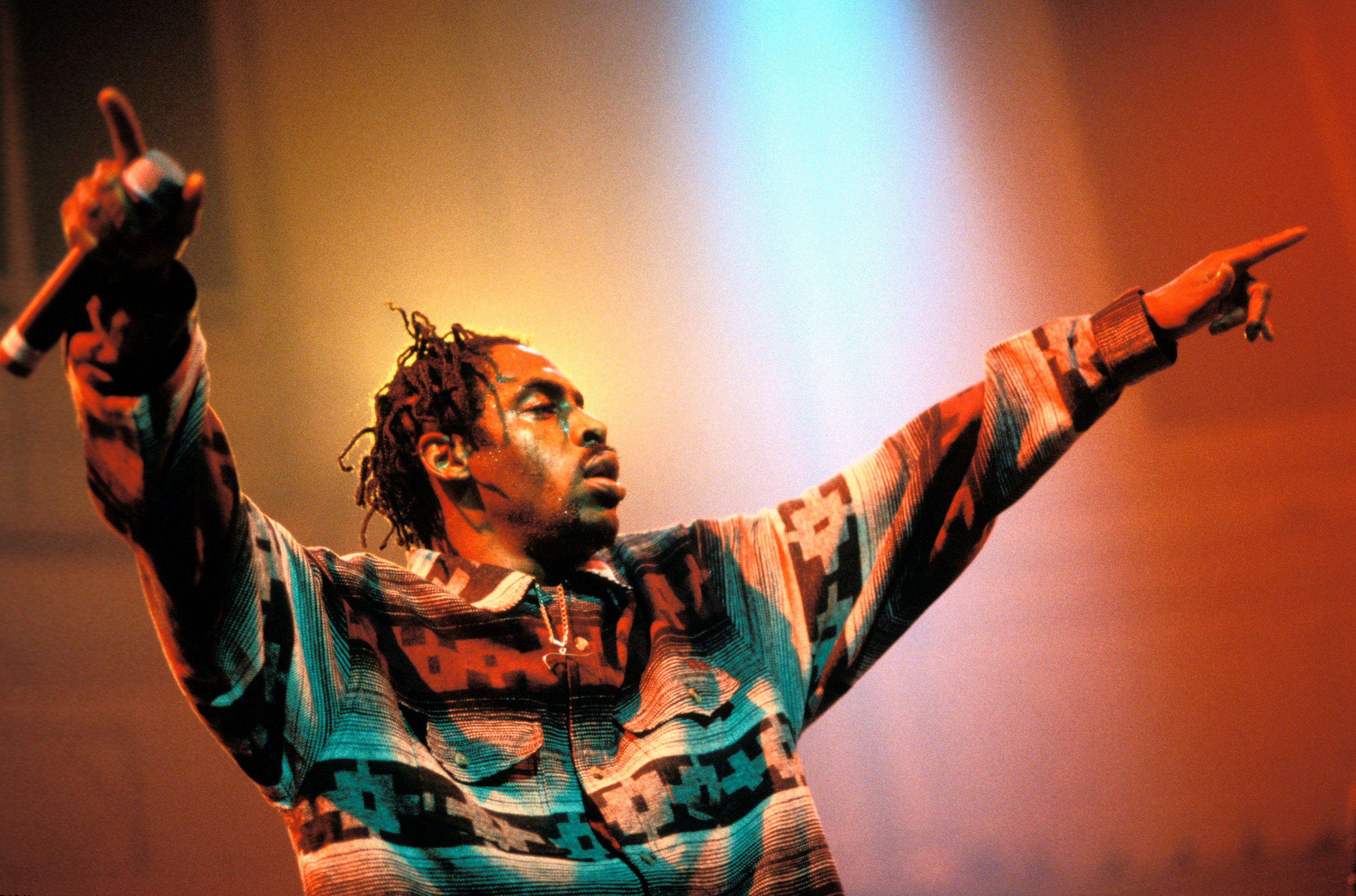 Coolio raises his hands and performs during a concert.